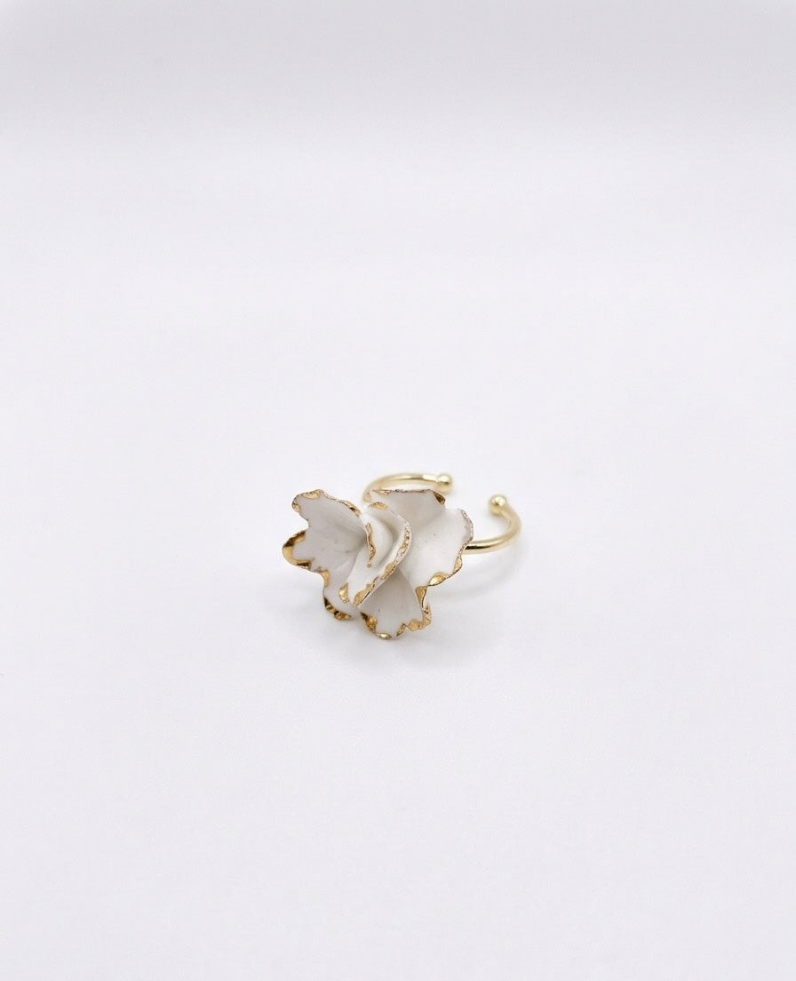 White ceramic floral ring with gold edges and a gold band on a white background