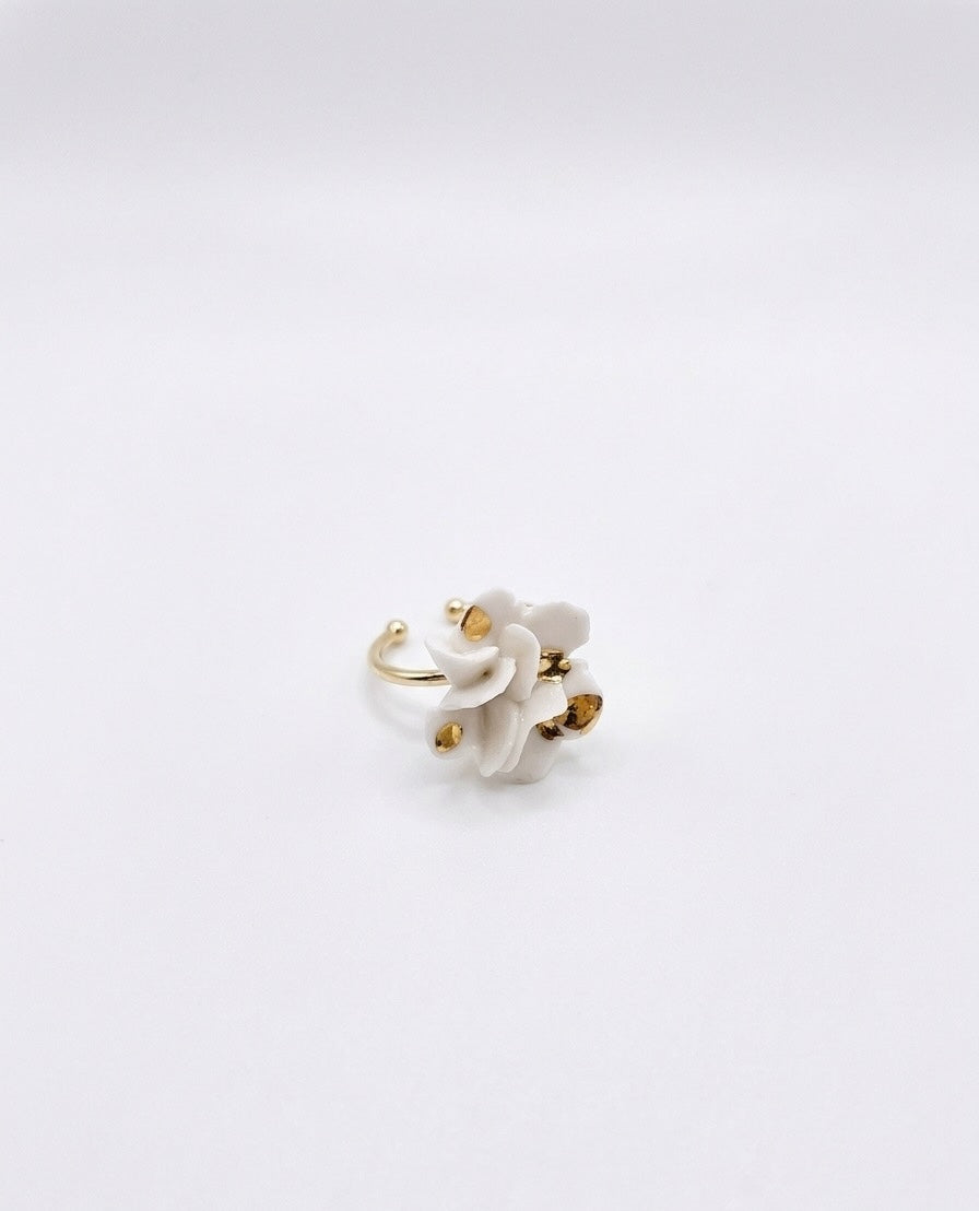 A gold ring featuring multiple small white flower accents